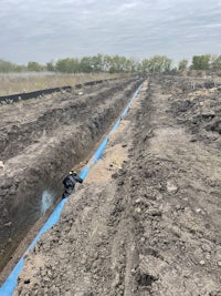 a blue pipe is being installed in a field